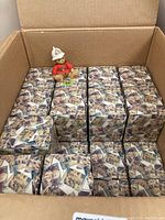 One cardboard box filled with approximately 25 smaller boxes containing Precious Moments figurines, with one bear figurine displayed outside a box.