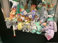 Shelf of Precious Moments plush animals and aquatic characters showing various stuffed birds, dolphins, and other plush toys.