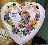 Heart-shaped Cherished Teddies promo tin top showing floral design and Cecilia bear image