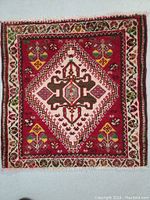 Front of the Shiraz wool rug showing the geometric central medallion and colorful floral border.