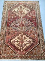 Full view of rug laid flat showing triple medallion pattern and border