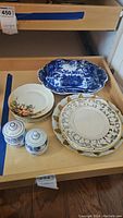 Photo of dishware set showing 5 small Versailles Bavaria plates, blue and white covered serving dish, small lidded containers, floral vine design plates and serving dish
