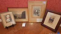 Four framed engravings displayed together showing varied subjects and frame styles.