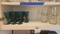 Shelf with 10 turquoise etched glass cocktail glasses and 4 clear old fashioned glasses