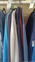 Photo of multiple women's sweaters and cardigans in various colors hung on hangers