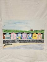 Full view of hand painted beach huts on canvas with natural background in painting.
