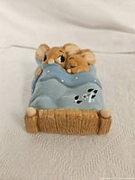 Front view of the handpainted Pendelfin Bunny Twins figurine showing two bunnies sleeping under a blue blanket with a wooden bed base.
