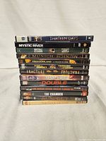 Stack of 13 DVDs including titles such as Thirteen Days, Mystic River, Buffalo Soldiers, Munich, Freedomland, Sunset, Fracture, Vantage Point, The Double, Law Abiding Citizen, The Chamber, Suspect, and The Good Mother.