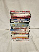 Stack of 21 DVDs featuring teen and family comedy movies with visible titles.