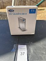 Front of retail box showing LaCie d2 Quadra 4TB USB 3.0 storage with product image and storage capacity