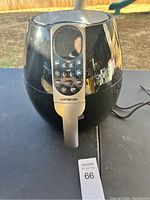 Full front view of the black GoWISE USA air fryer showing its glossy round shape, silver handle, and digital control panel.