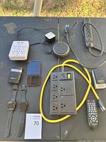 Overview of lot showing watches, smartphone, power strips, Echo Dot, remote, and chargers