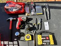 Full view of the lot of tools including hammer, cordless screwdriver, pliers, saw, measuring tape, rope, pry bar, multi-tool, and small hand tools pouch.