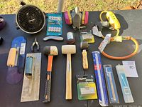 Overview of all tools and items laid out on a table outdoors on grass.