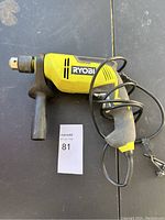 Full view of the Ryobi hammer drill showing side handle, power cord, and Ryobi branding.