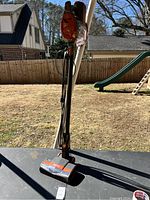 Full view of the Shark Rocket stick vacuum standing upright outdoors on a table, showing the cord and brush head.