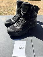 Full view of the pair of black Under Armour boots outdoors showing general appearance and size 12.