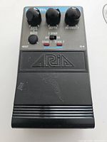 Front view of the chorus effect pedal showing control knobs Rate, Depth, Intensity, and stage selection switches plus Aria logo on the foot pedal.