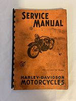 Front cover of the Harley-Davidson service manual showing orange cover with black text and image of a vintage motorcycle.
