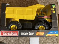 Front angled view of Tonka Mighty Dump truck in box with visible branding and partial exposure of the truck inside.