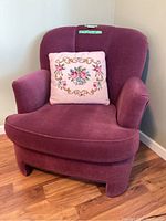 Full view of the burgundy armchair with pink floral cushion placed on it.