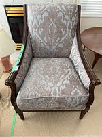 Front view of decorative armchair showing patterned upholstery and wooden frame.