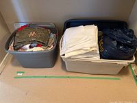 Two large plastic storage bins containing assorted fabric pieces in various colors and patterns.