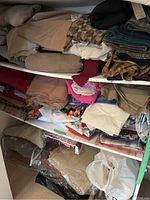 Shelf with folded fabrics in beige, patterned, and mixed colors