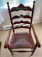 Front view showing wooden ladder back slats, armrests, and woven seat with approximate dimensions labeled.