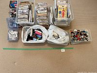 Wide shot of various sewing patterns in bins and thread spools in containers on floor