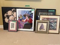 Seven pieces of wall art: one large canvas with floral design, five framed art pieces including a colorful woman illustration, floral and landscape paintings, and a small hearts print.