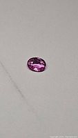 Loose pink oval sapphire on neutral background