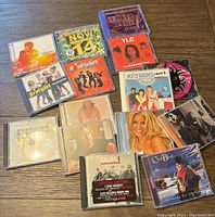 Overview of all 13 CDs stacked and laid out on table showing album cover art and titles