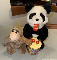 Photo showing both the Panda Luck battery operated toy and the ALF plush toy on a flat surface.