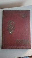 Photo of the front cover of the yearbook, maroon with gold lettering showing '1940' and 'Marmon'.