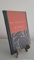 Front view of the hardcover book with dust jacket titled 'The Time Machine' by H.G. Wells showing the spine and part of the cover.