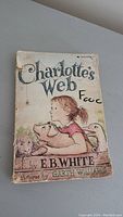 Front cover of Charlotte's Web showing title, author, illustrator, and wear.