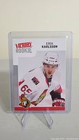 Front view of Erik Karlsson rookie hockey card in plastic holder showing player in Ottawa Senators uniform.