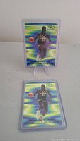 Front image of one Shaquille O'Neal basketball card in black Cole jersey with green and blue background.