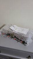 Photo of the Sinclair Duplexer unit wrapped in bubble wrap with paperwork on top, showing the physical condition and packaging contents.