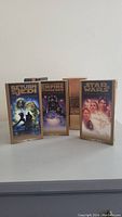 Three VHS tapes standing side by side with visible cover art and part of their original box set packaging. Shows Return of the Jedi, The Empire Strikes Back, and Star Wars Special Edition tapes.