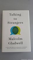 Front cover of 'Talking to Strangers' hardcover book by Malcolm Gladwell showing title, author and subtitle inside speech bubbles on a white background.