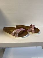 Side and angled view of pink Birkenstock ladies sandals showing the adjustable straps, cork footbed, and white sole.