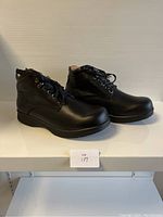 Side angle of black leather lace-up shoes showing smooth leather finish and sole design.