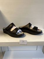Side view of the black ladies sandals showing open-toe and velcro straps.
