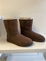 Side view of brown UGG Classic Short boots showing their shape and condition.