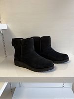 Side view of pair of black UGG boots showing full profile