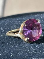 Front view showing round purple gemstone in four-prong 10K gold setting