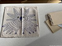 Canvas folder front showing single snowy owl face print in blue and black ink, fringed edges.