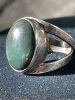 Side angle of sterling silver ring with green and red speckled bloodstone and split shank design.